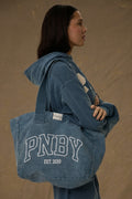 Model carrying Pennbury PNBY vintage navy canvas tote bag