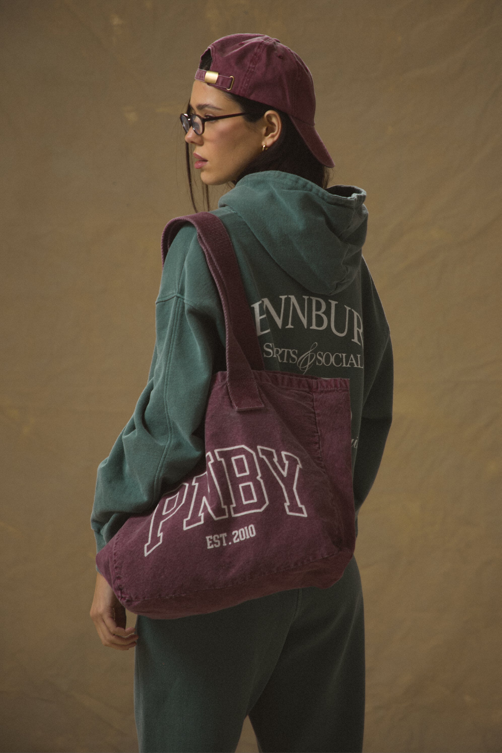 Model carrying Pennbury PNBY vintage wine canvas tote bag