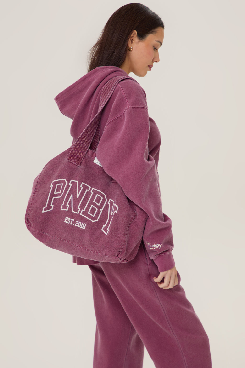 Model carrying Pennbury PNBY vintage wine canvas tote bag