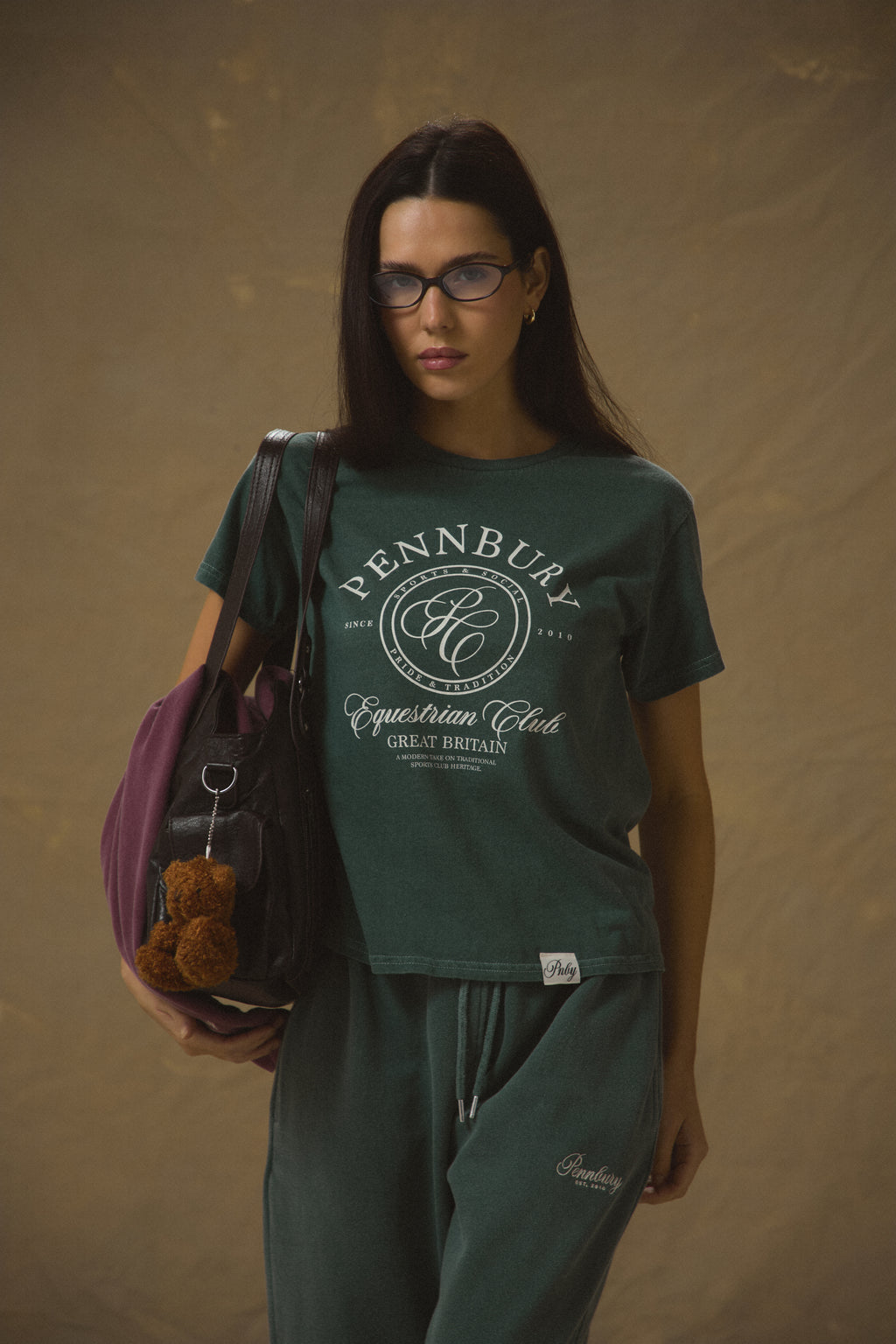 Model wearing Pennbury Pavilion baby tee in racing green with joggers