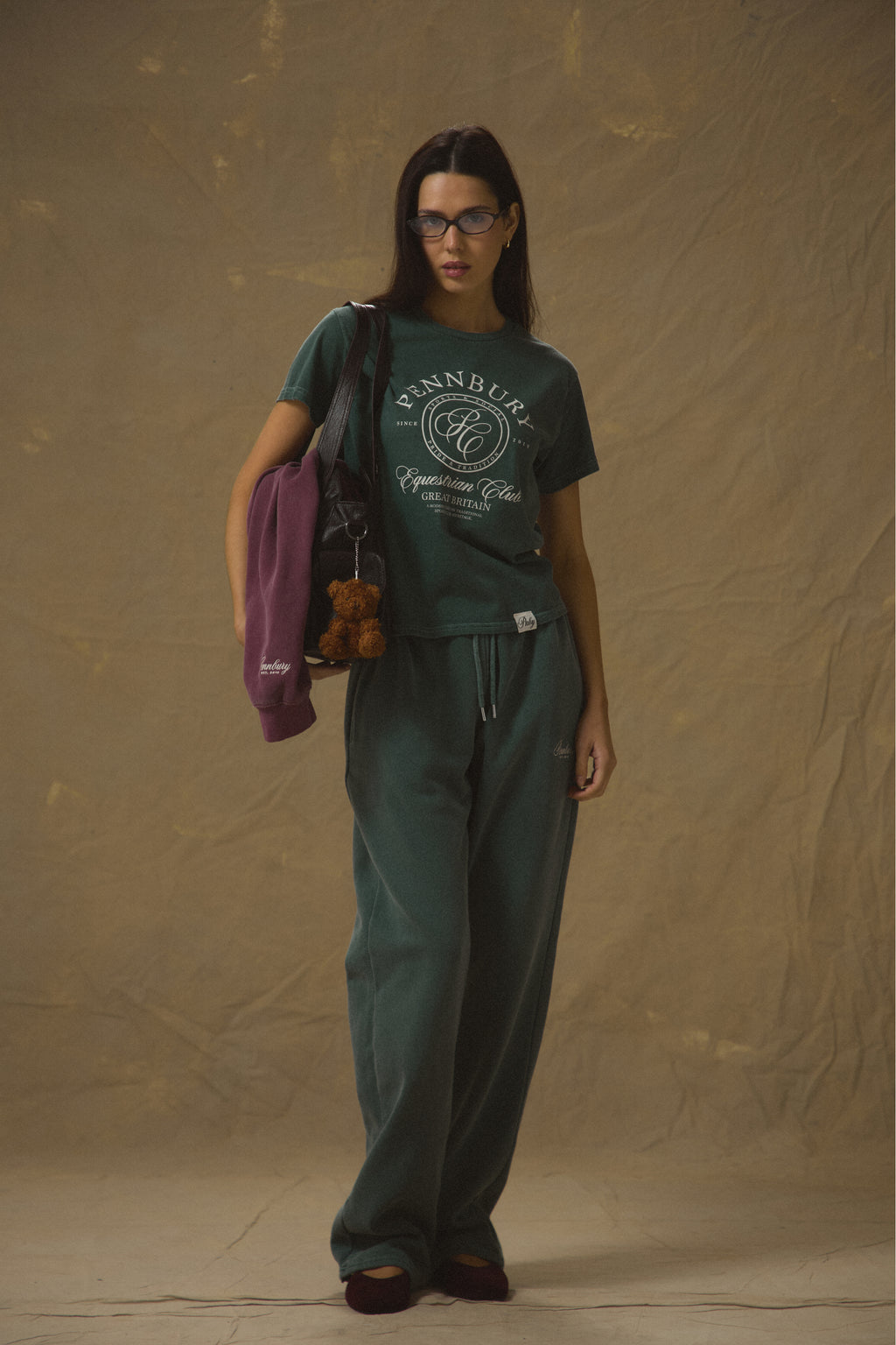 Model wearing Pennbury Pavilion baby tee in racing green with joggers