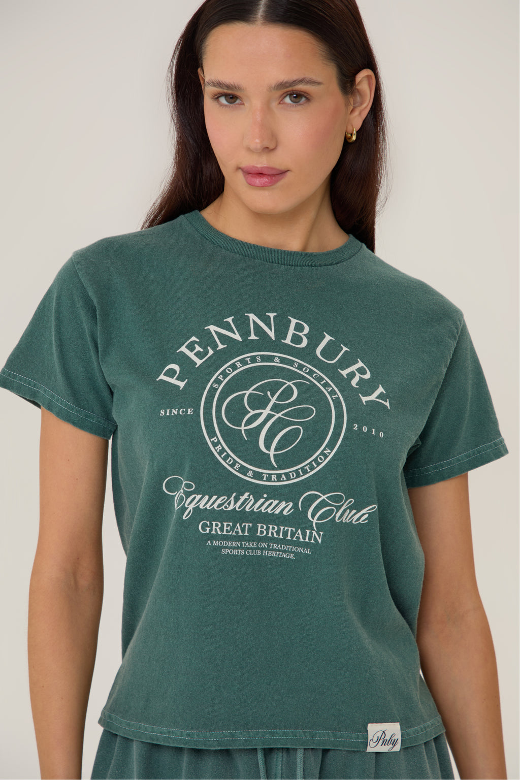 Model wearing Pennbury Pavilion baby tee in racing green with joggers