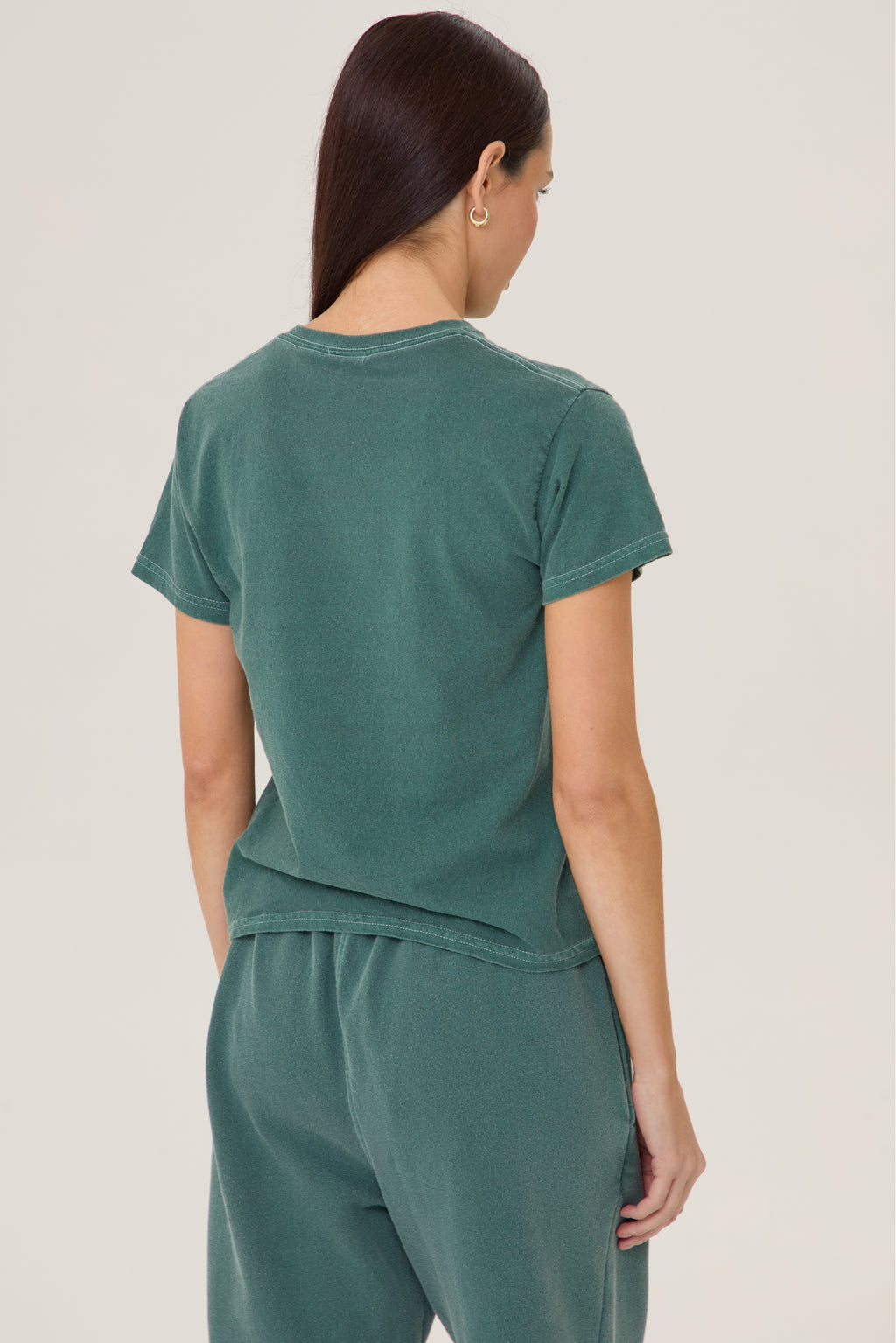 Model wearing Pennbury Pavilion baby tee in racing green with joggers