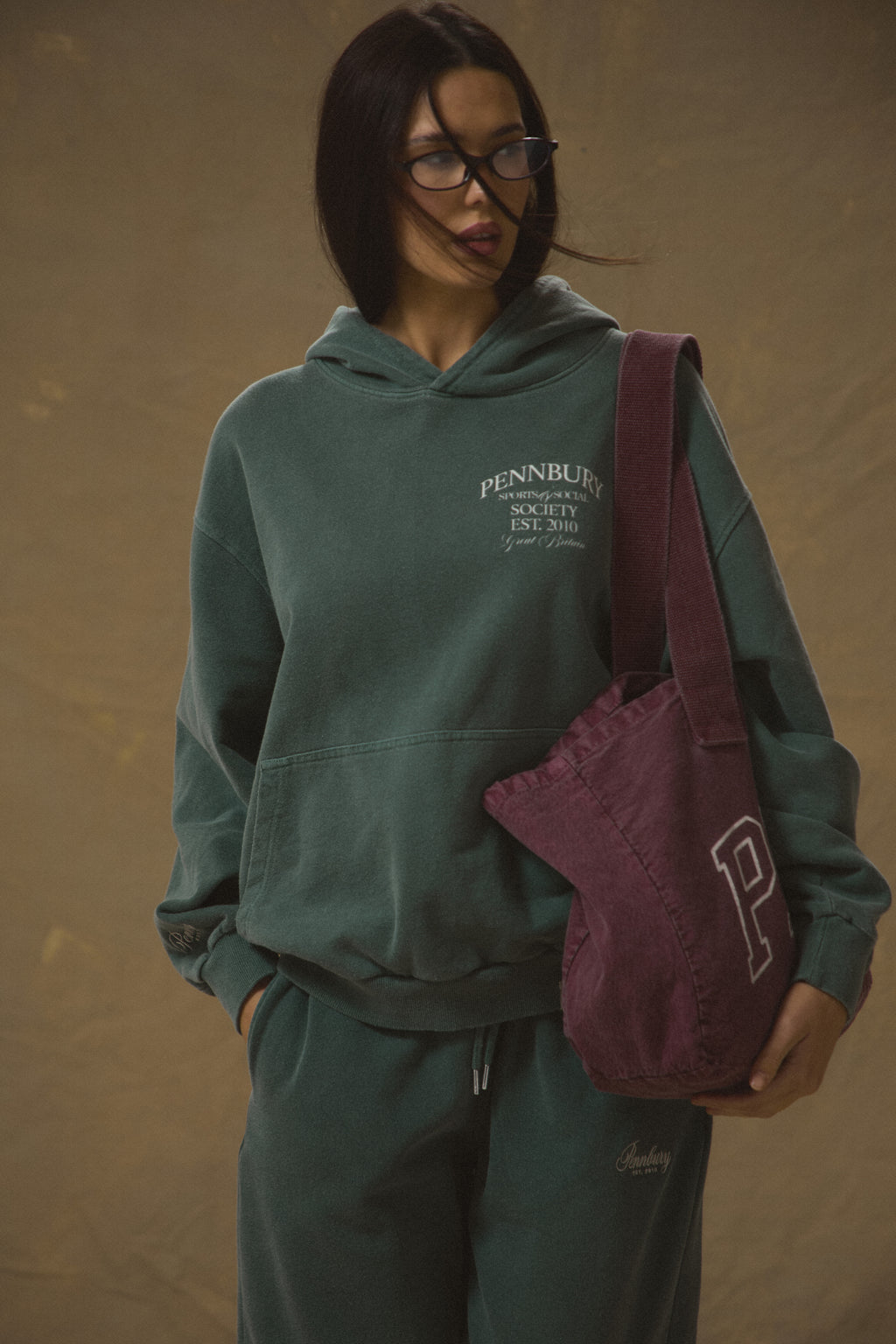 Model wears Pennbury Sports & Social Hoodie in vintage green