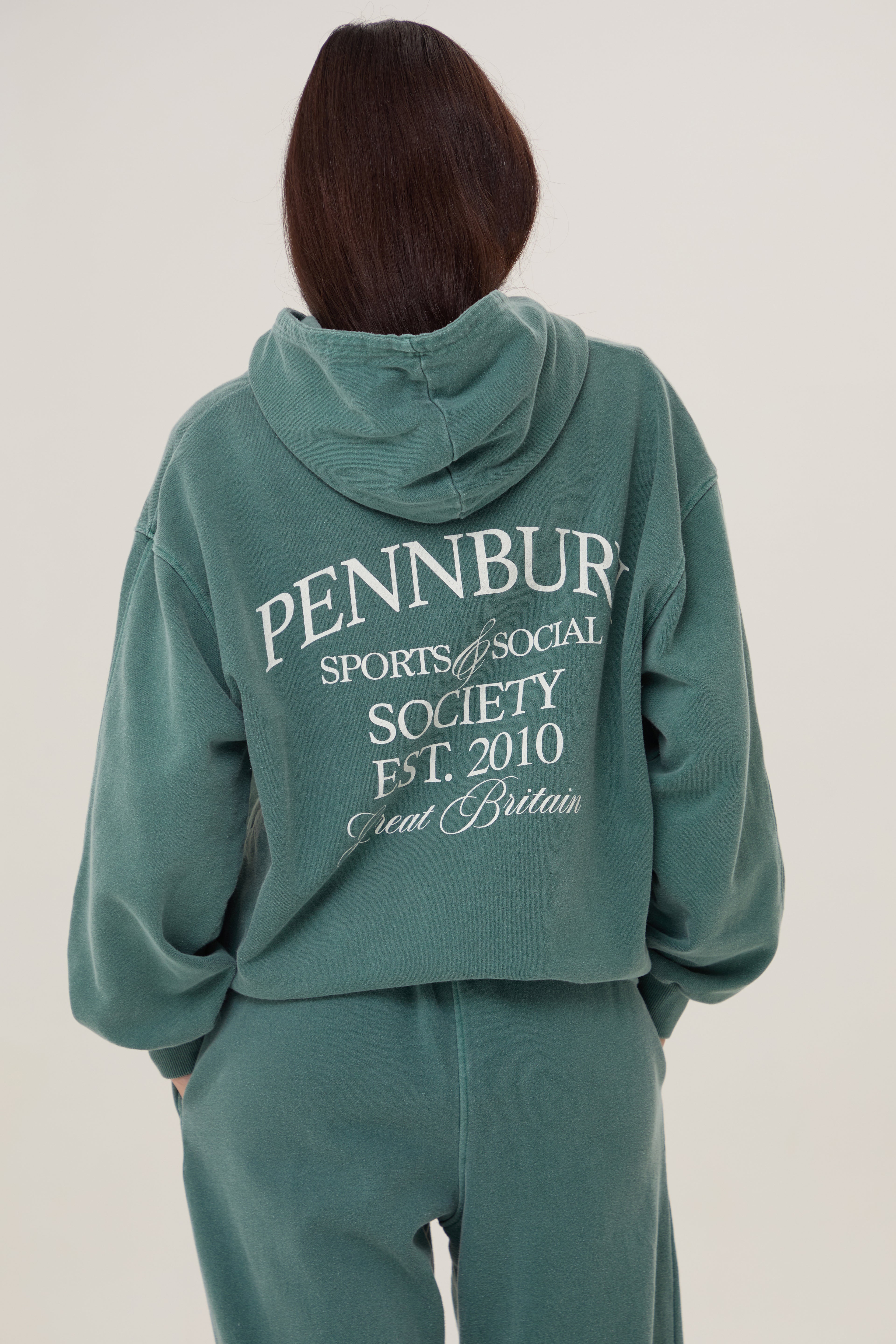 Model wears Pennbury Sports & Social Hoodie in vintage green 