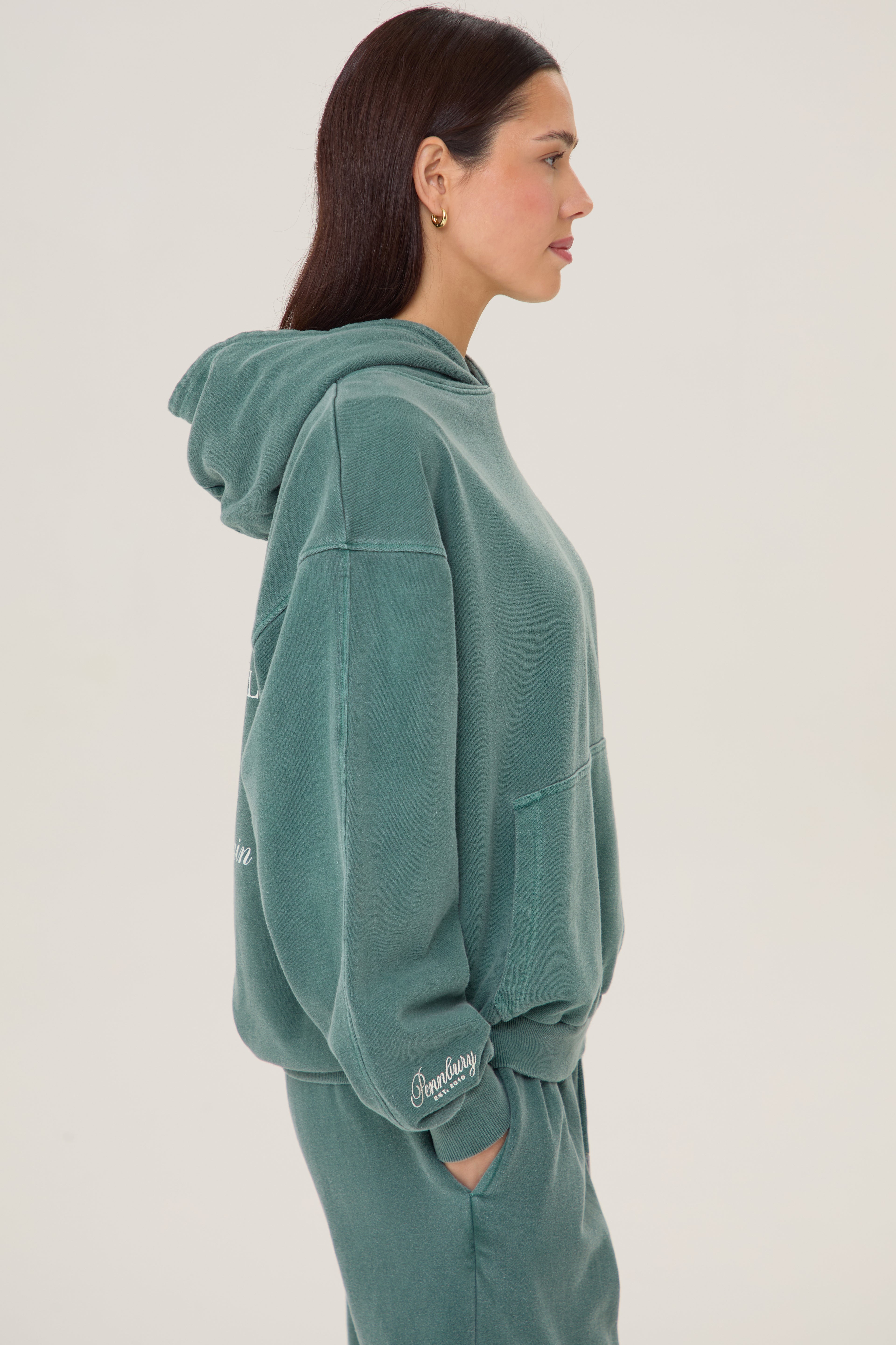 Model wears Pennbury Sports & Social Hoodie in vintage green 
