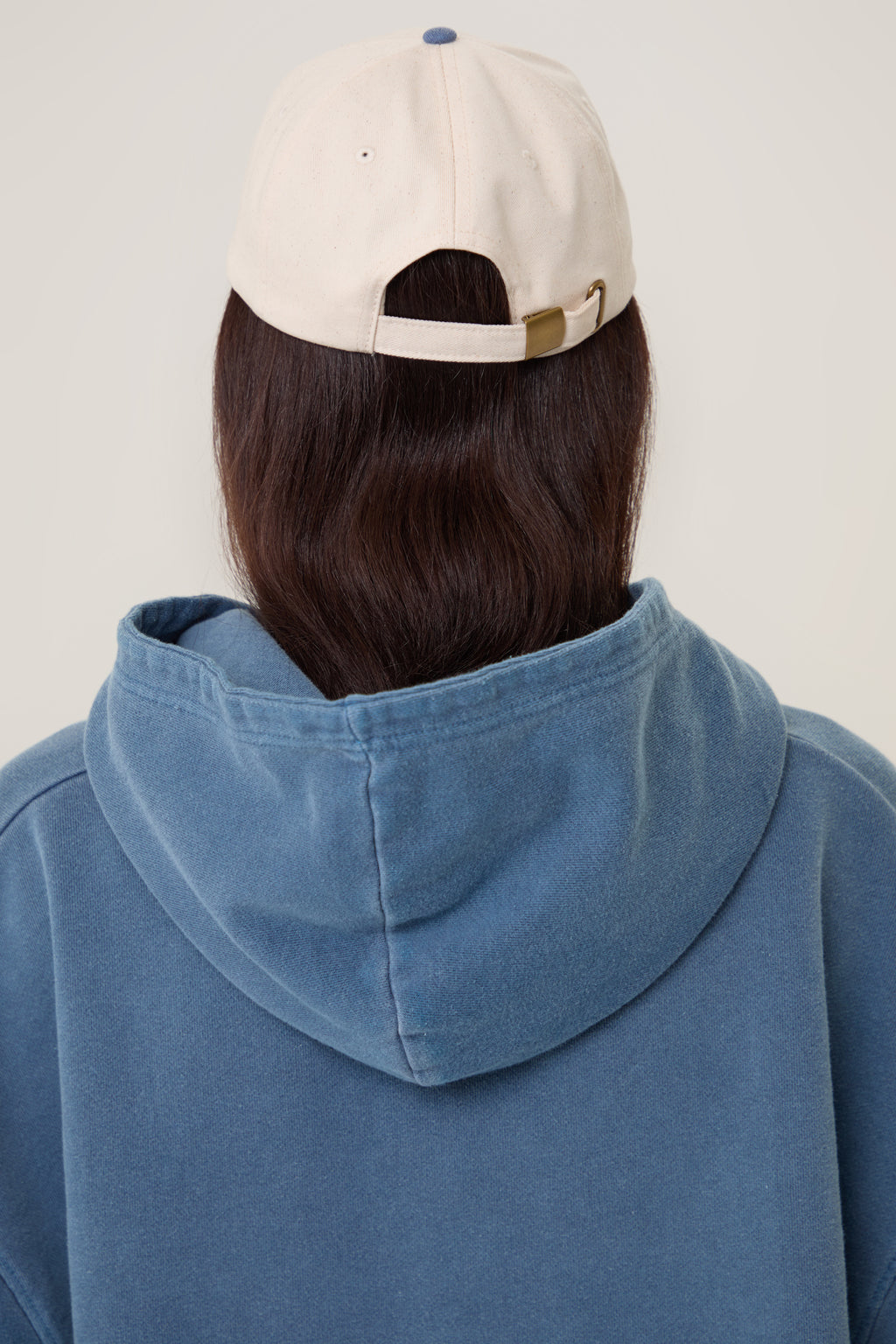 Model wearing Pennbury oat and blue embroidered tennis cap