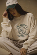 Model wearing Pennbury oat and green embroidered tennis cap