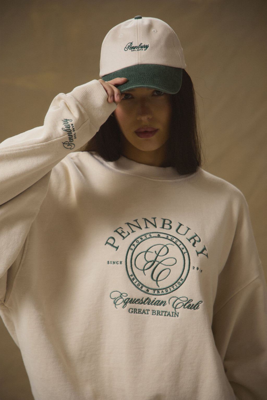 Model wearing Pennbury oat and green embroidered tennis cap