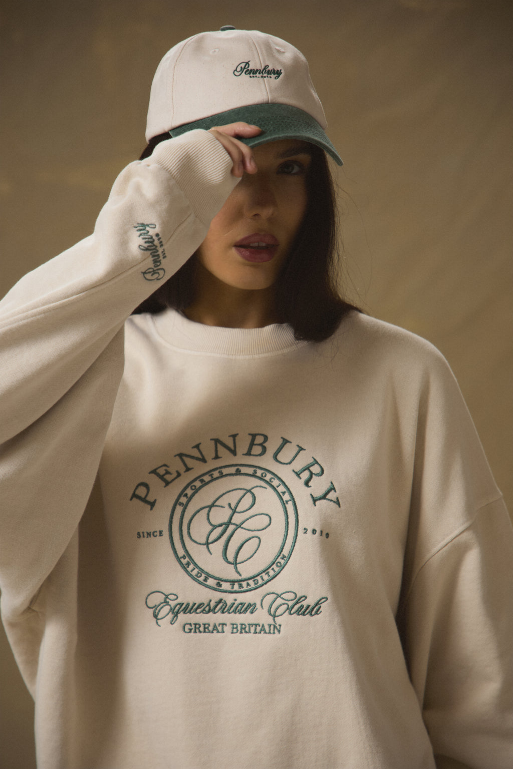 Model wearing Pennbury oat and green embroidered tennis cap 
