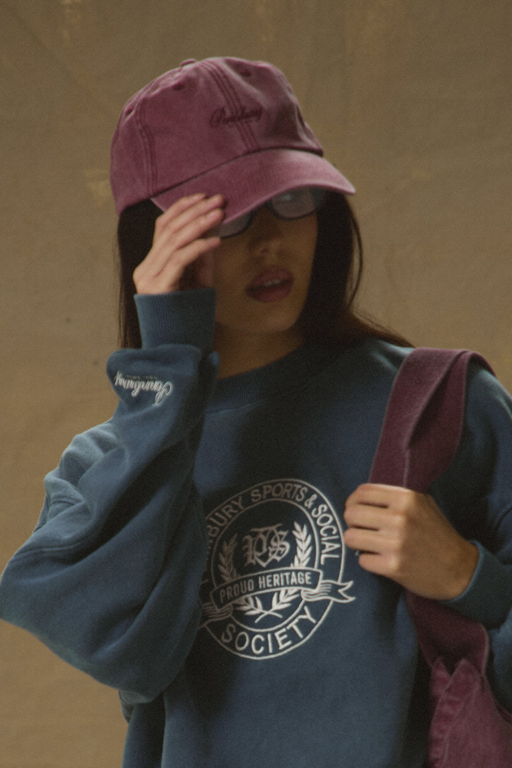Model wearing Pennbury vintage wine embroidered tennis cap