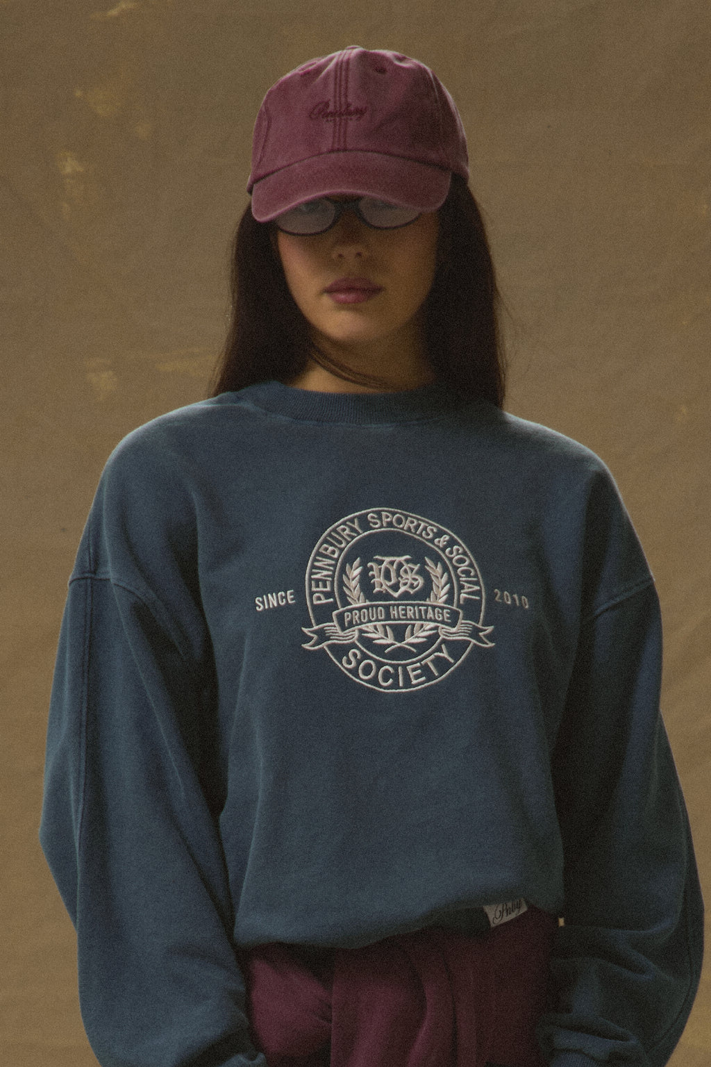 Model wearing Pennbury vintage wine embroidered tennis cap