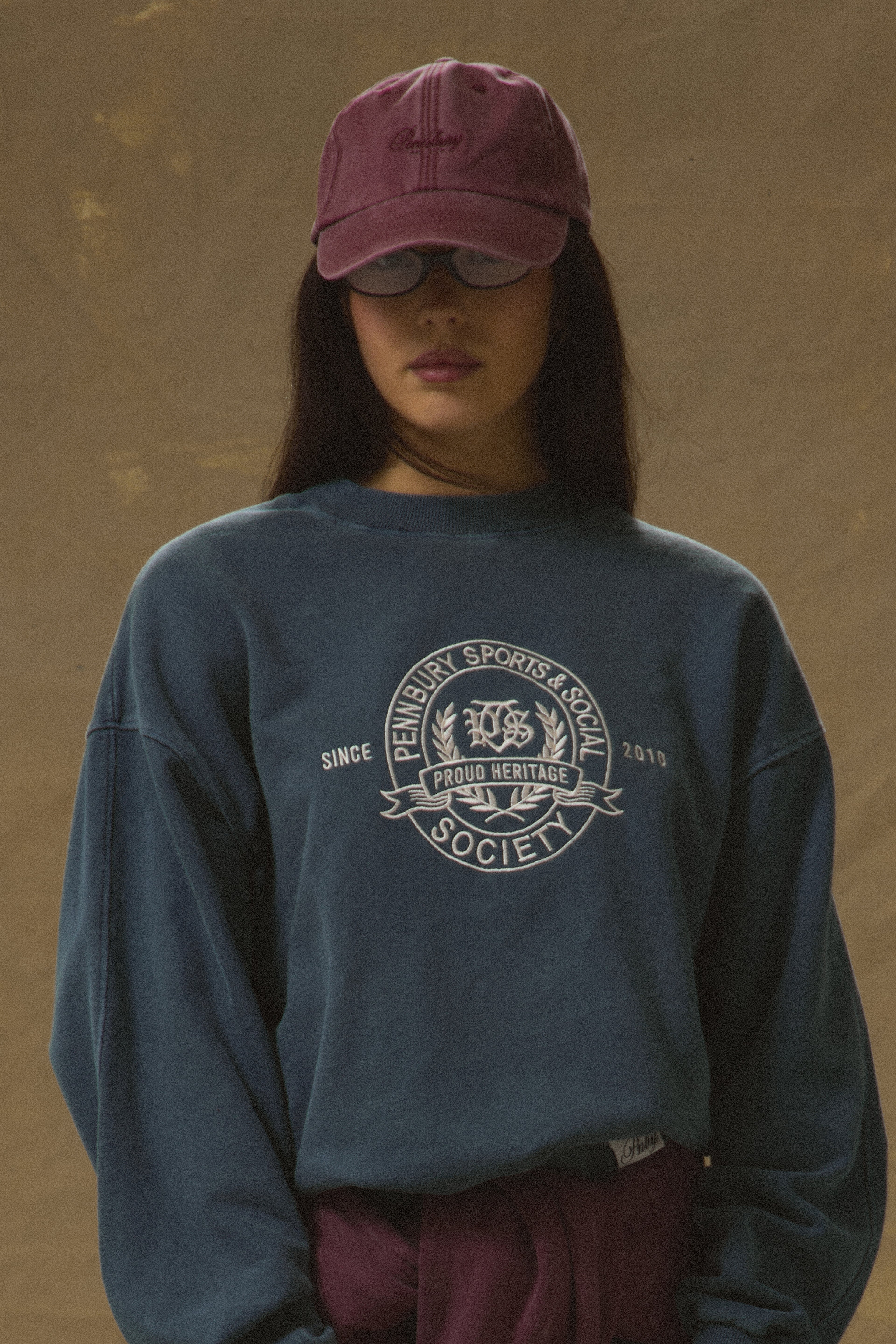 Model wearing Pennbury vintage wine embroidered tennis cap