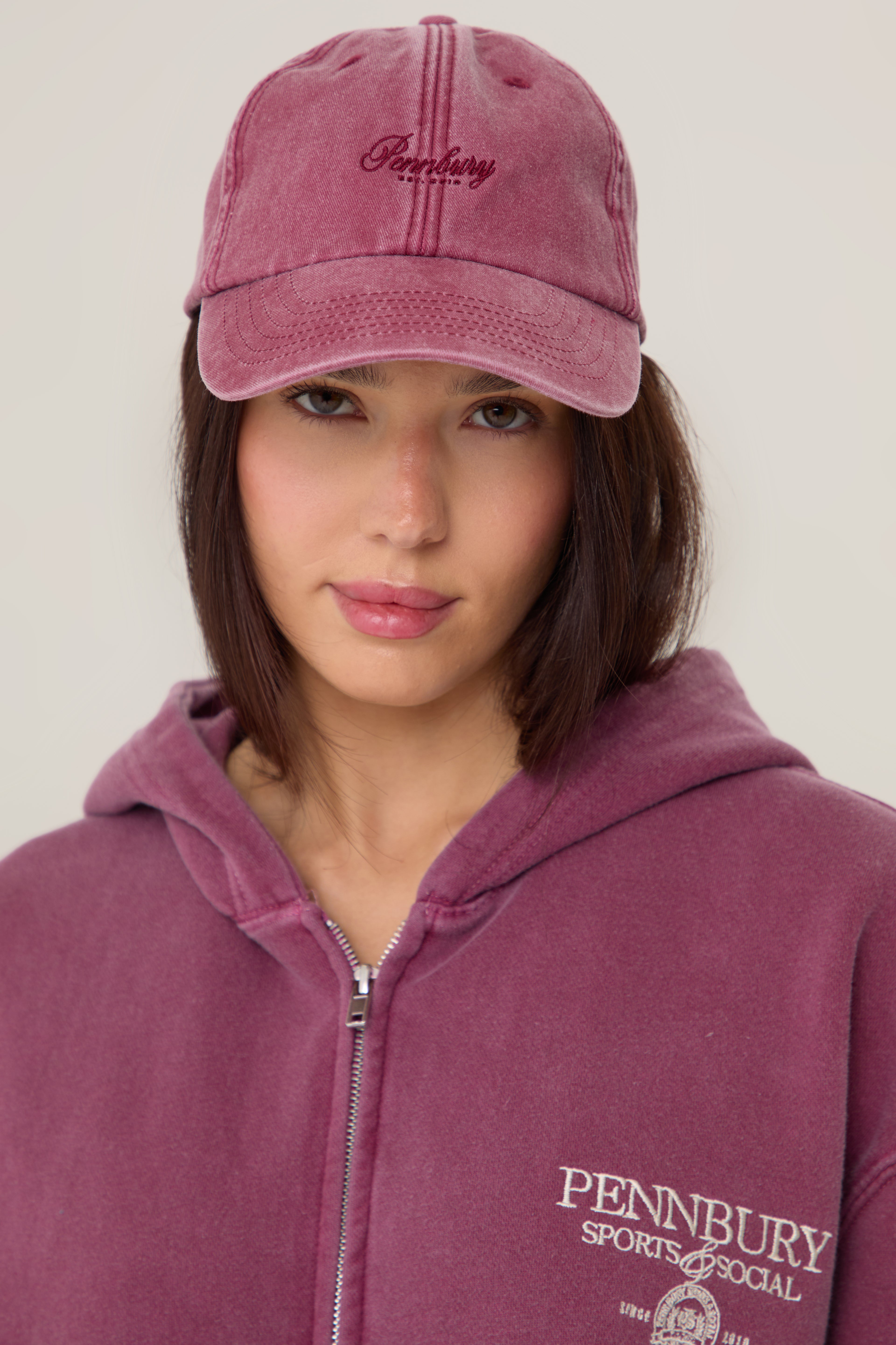 Model wearing Pennbury vintage wine embroidered tennis cap