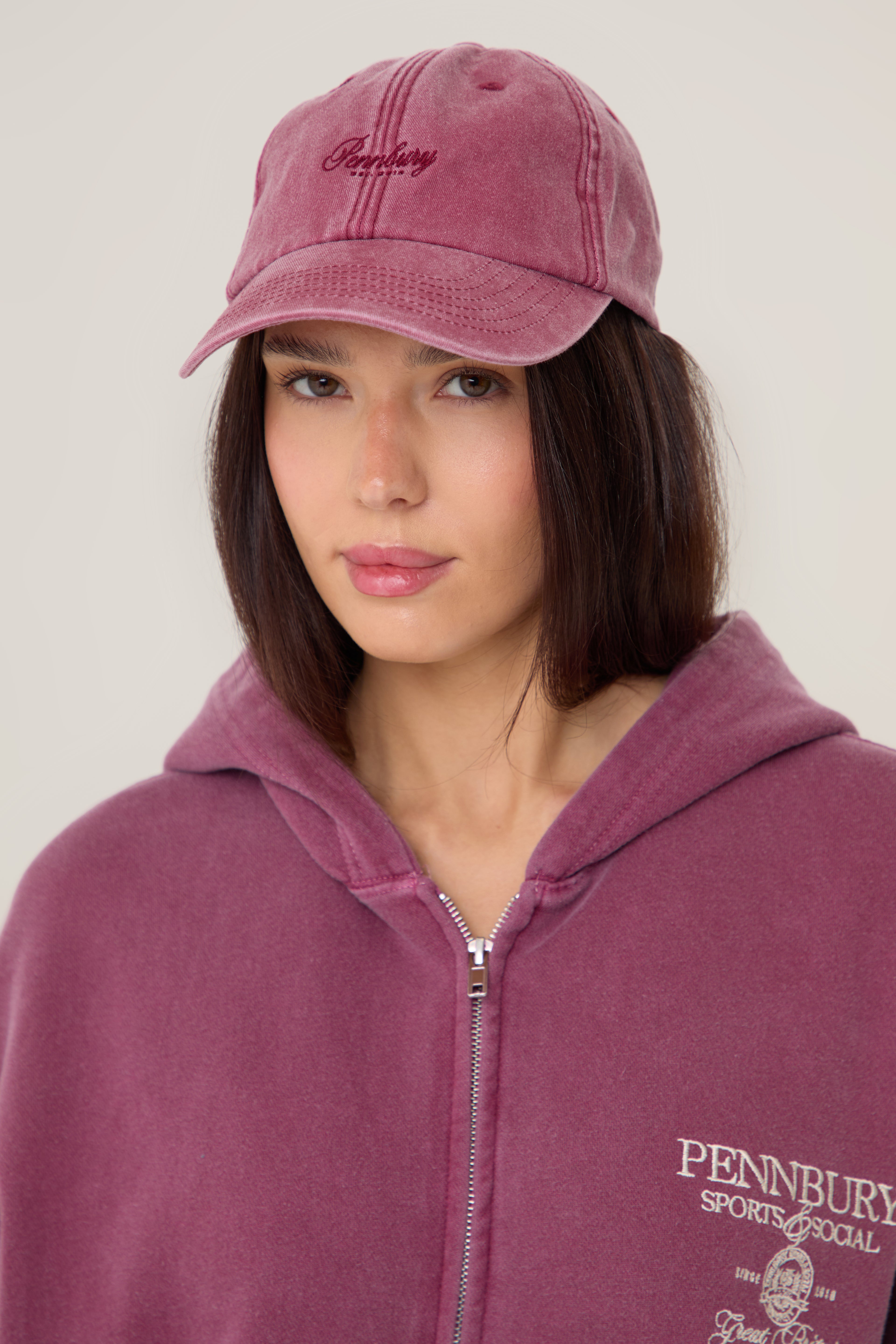 Model wearing Pennbury vintage wine embroidered tennis cap