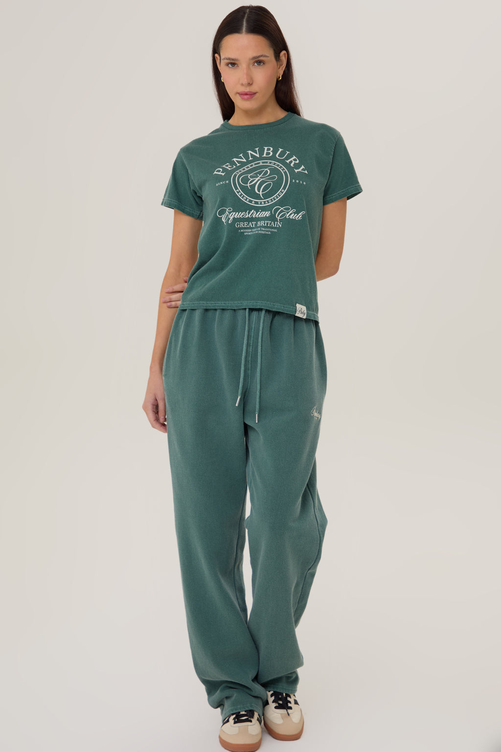 Model wearing Pennbury Pavilion baby tee in racing green with joggers